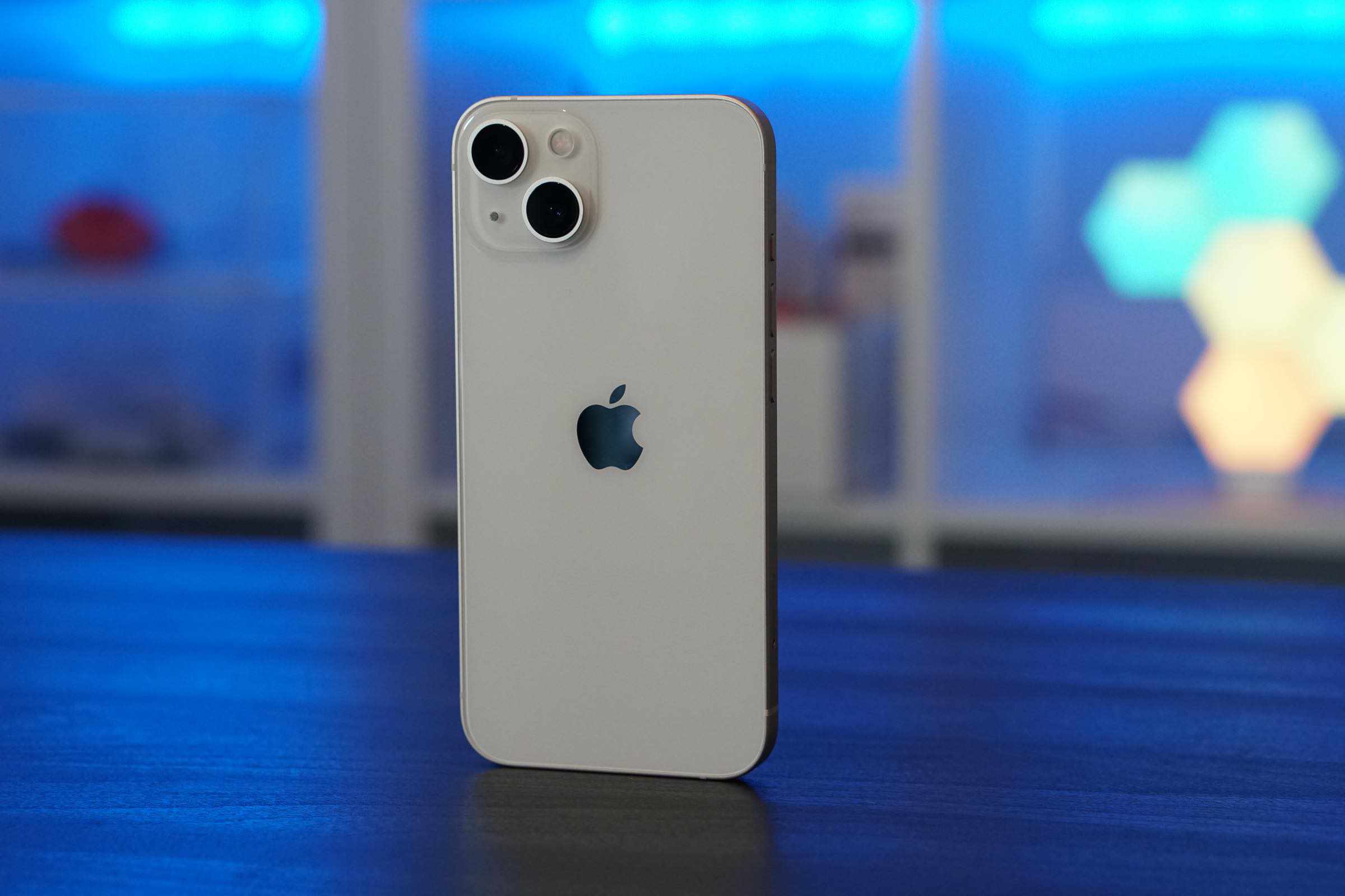 iPhone 13 Rückseite vor einem verschwommenen blauen Hintergrund